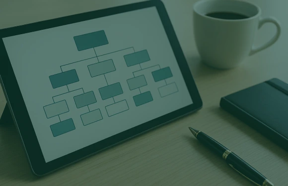 Tablet mit Organigramm, Kaffeetasse, Stift und Notizbuch – Janusberg® entwickelt strukturierte Investmentpläne und Gesellschaftsmodelle für erfolgreiche Immobilieninvestitionen.